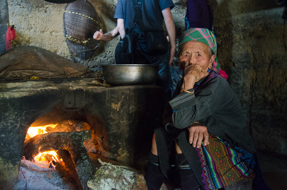 Old vietnamese woman near a wood stove